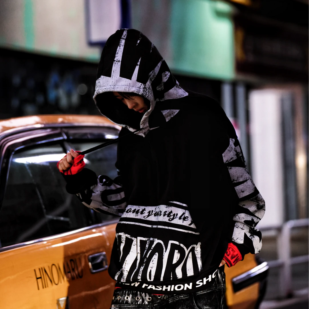An oversized hip-hop top made with thermal fleece fabric, full-surface graffiti graphics, and patchwork details. A high-street essential by Sanhoostudio.