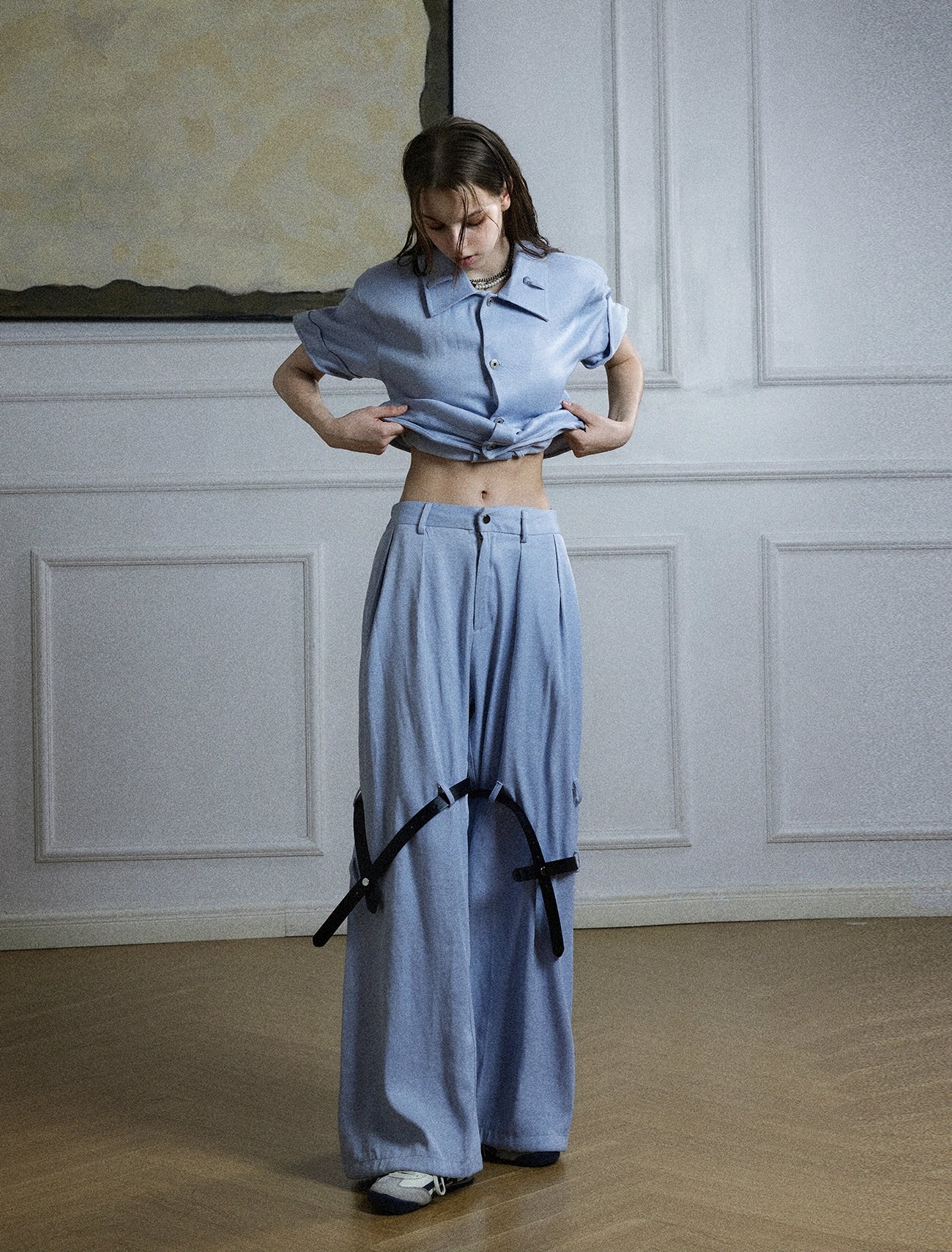 The Sanhoostudio twill textured pants showcase structured tailoring with unique belt-inspired patchwork. Combining minimalism with avant-garde detailing, they bring an elevated urban aesthetic to both casual and semi-formal styling.
