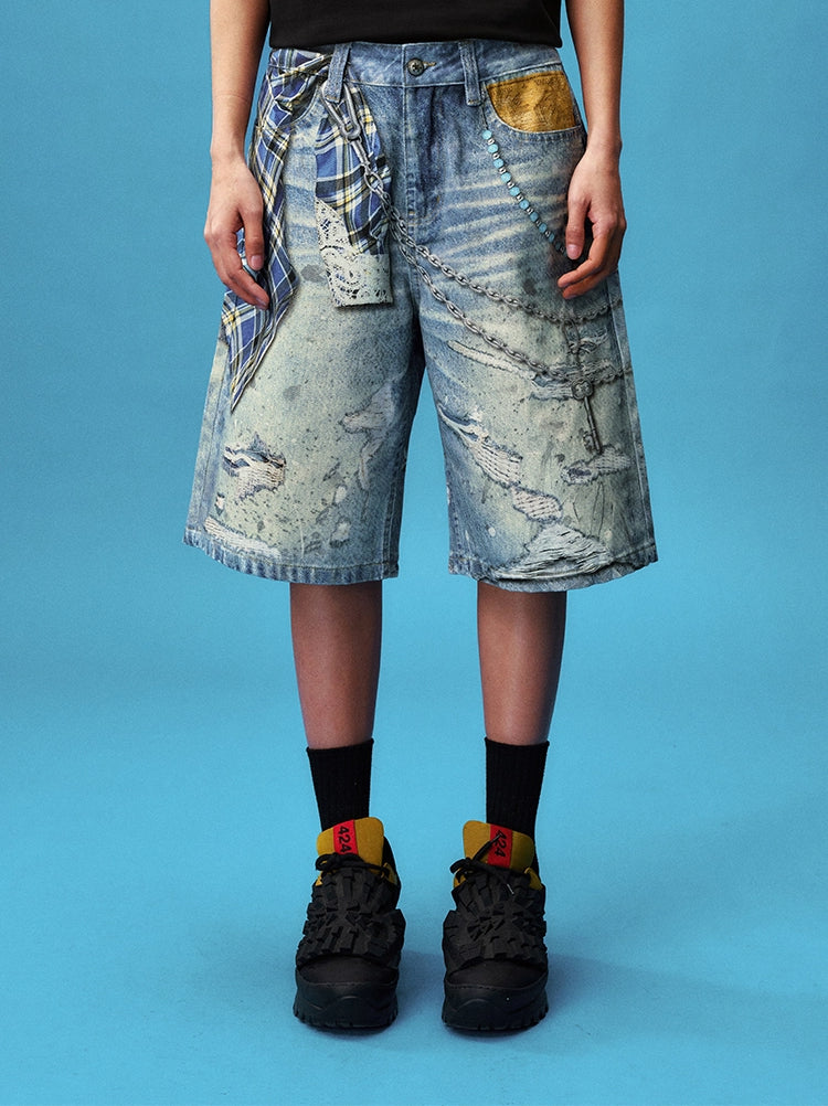 These Sanhoostudio denim shorts feature plaid-inspired patterns with chain print accents, merging casual denim with bold graphic expression. With a relaxed oversized fit, they’re ideal for layering into creative high street looks.