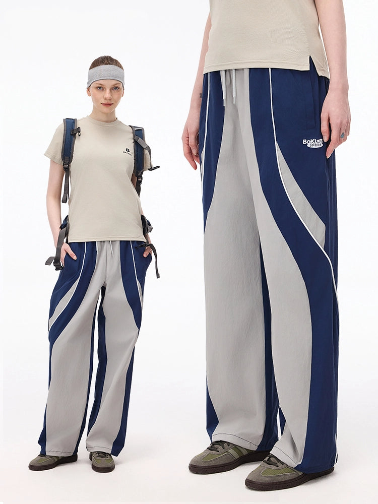 These vintage-inspired lightweight sport pants from Sanhoostudio feature a water-resistant finish and relaxed fit. Perfect for casual outings or streetwear looks with a retro athletic twist.