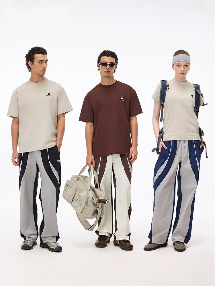 These vintage-inspired lightweight sport pants from Sanhoostudio feature a water-resistant finish and relaxed fit. Perfect for casual outings or streetwear looks with a retro athletic twist.