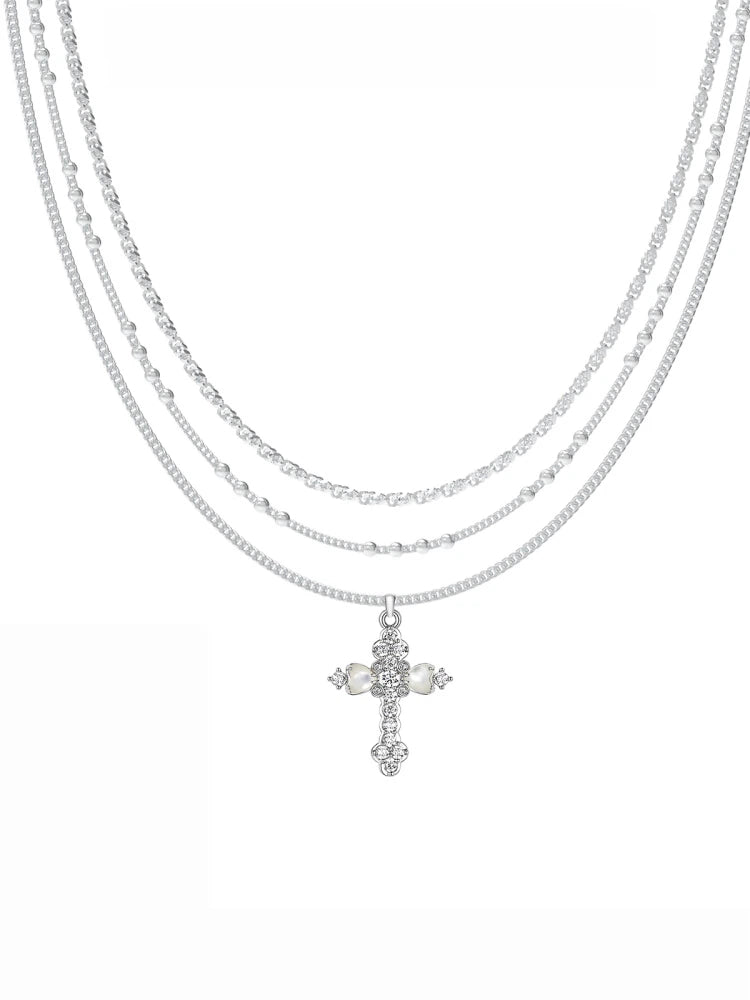 Embrace soft elegance with Sanhoostudio’s layered petal cross necklace. Adorned with mother-of-pearl accents, it brings timeless charm and modern refinement to your style.