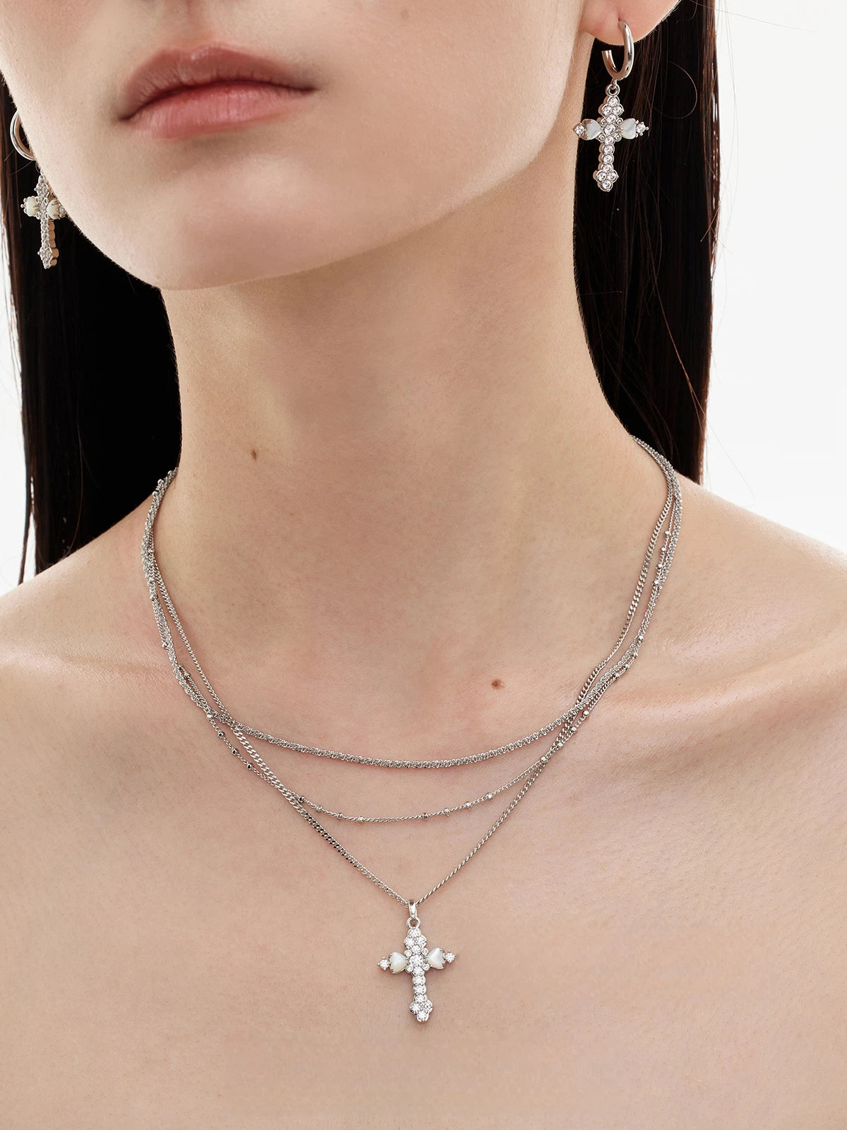 Embrace soft elegance with Sanhoostudio’s layered petal cross necklace. Adorned with mother-of-pearl accents, it brings timeless charm and modern refinement to your style.