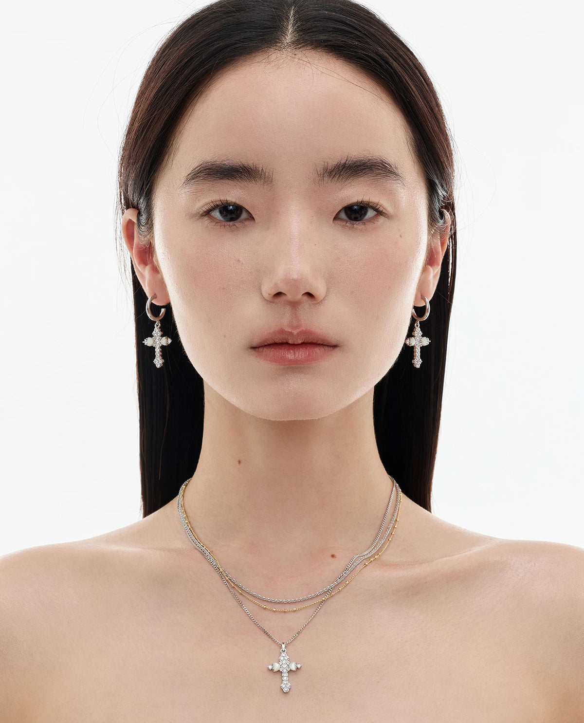 Embrace soft elegance with Sanhoostudio’s layered petal cross necklace. Adorned with mother-of-pearl accents, it brings timeless charm and modern refinement to your style.