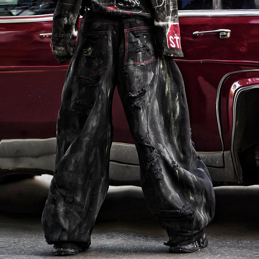 Sanhoostudio heavyweight denim pants featuring embroidery, graffiti details, and washed distressed texture. Designed with patchwork construction for bold unisex streetwear styling.