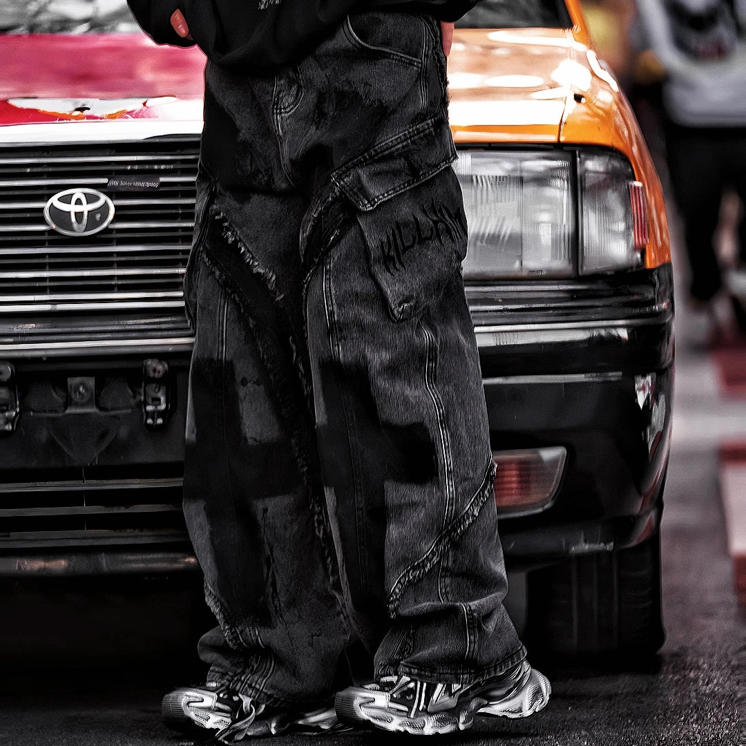 Sanhoostudio heavyweight denim featuring embroidery, graffiti artwork, and washed distressed finish. Designed with patchwork construction for bold unisex streetwear styling.