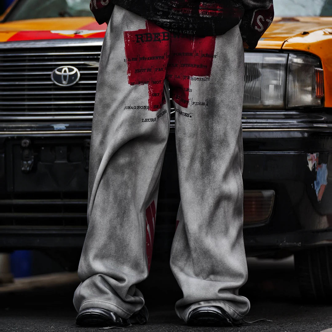 Sanhoostudio sweatpants featuring distressed letter graphics and fleece lining for warmth. Designed with an oversized wide leg fit for unisex vintage-inspired streetwear styling.
