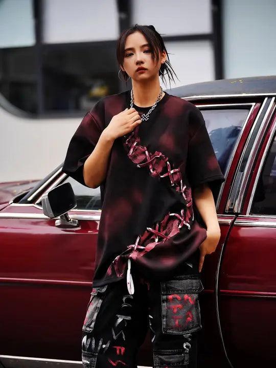 Sanhoostudio dark red T-shirt featuring spray dye effect and lace-up design. A unique streetwear piece combining bold color and artistic detailing.