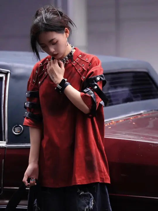 Sanhoostudio dark streetwear T-shirt featuring distressed dye finish, studded details, and leather patchwork accents. Designed with structured shoulder pads and a relaxed fit for bold summer styling.
