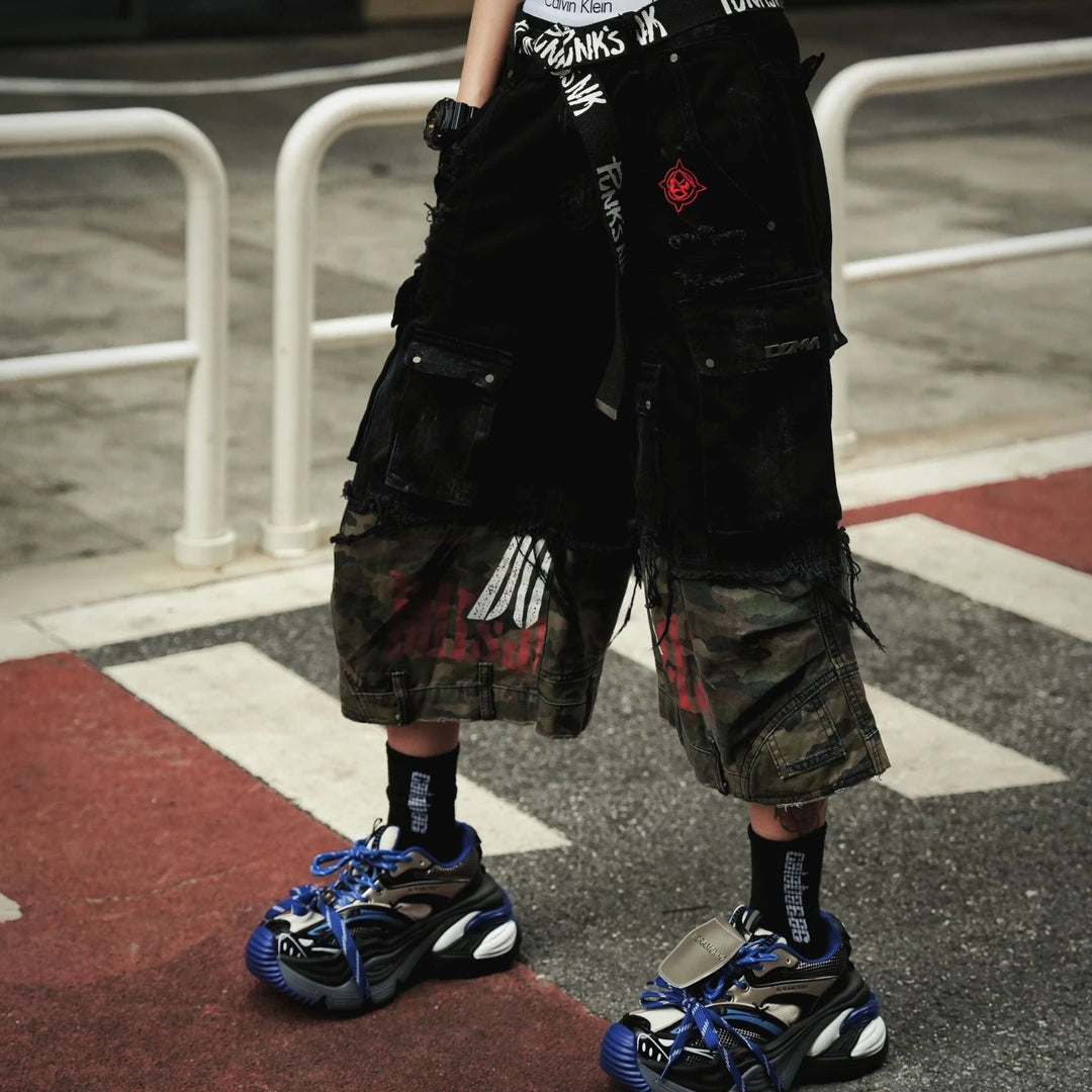 Sanhoostudio denim cargo shorts featuring camouflage patchwork design, multi-pocket construction, and wide leg silhouette. Perfect for summer streetwear styling with breathable comfort, functionality, and versatile daily wear.