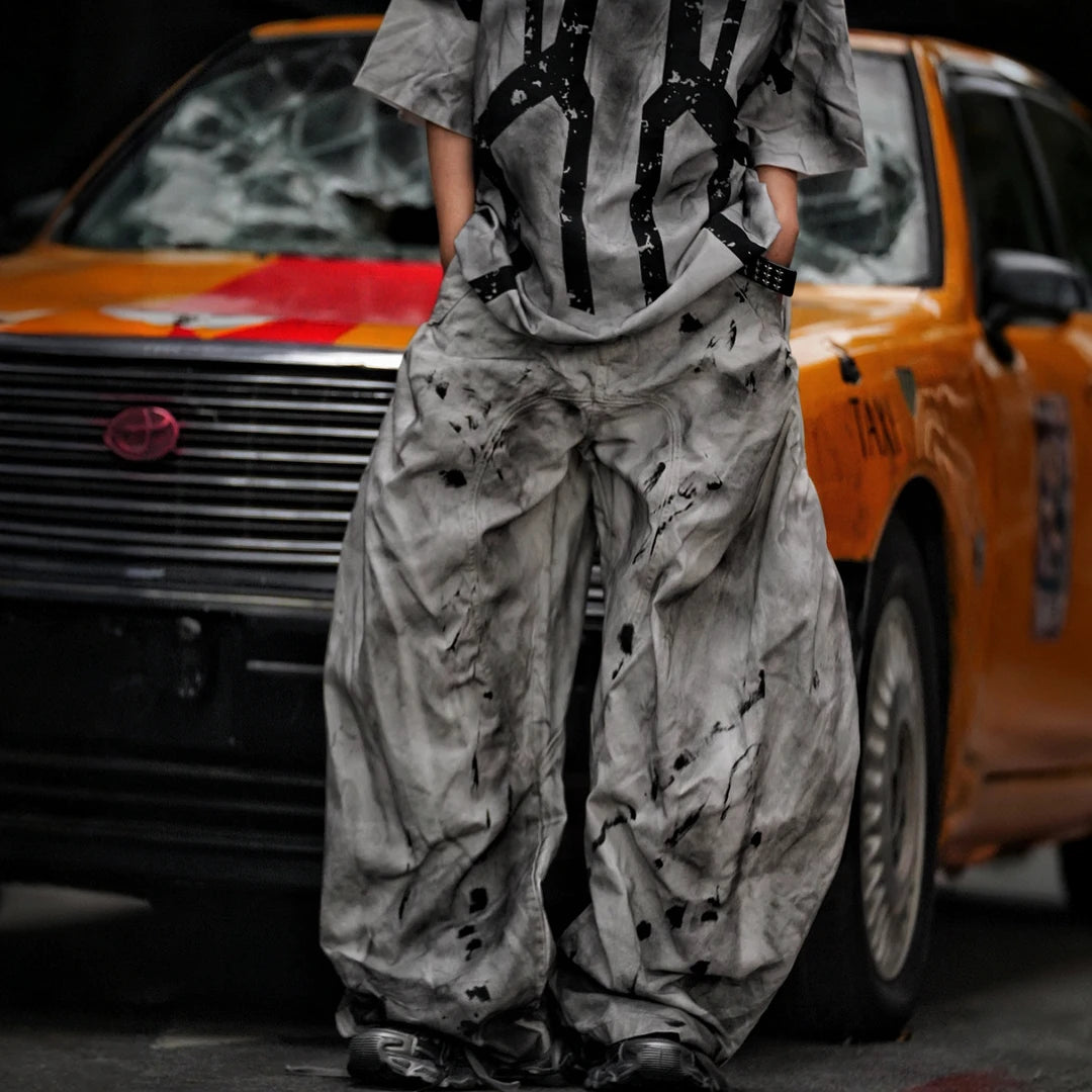 Sanhoostudio wide leg denim pants featuring distressed wash, embroidered detailing, and scythe-cut silhouette. Designed for bold streetwear styling with comfort, durability, and everyday versatility.