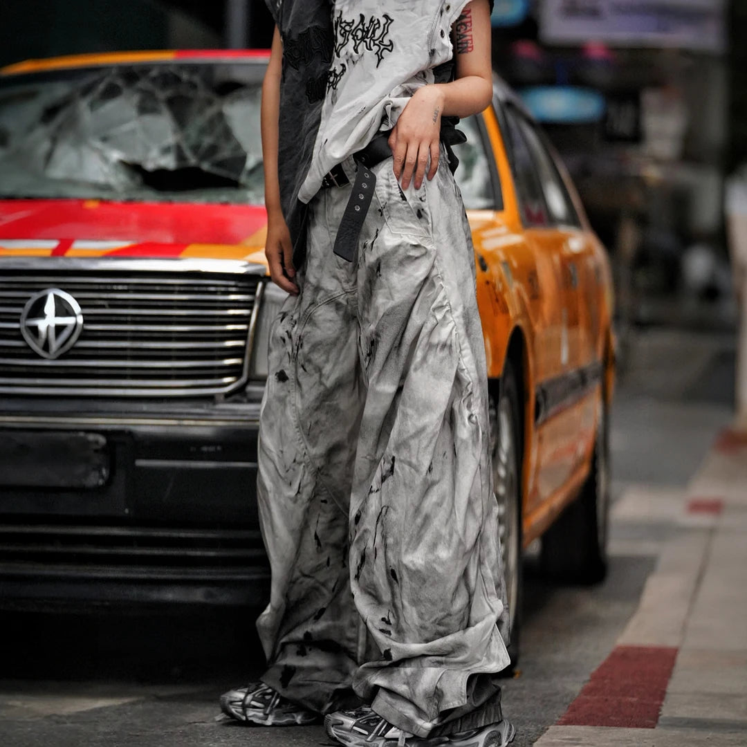 Sanhoostudio wide leg denim pants featuring distressed wash, embroidered detailing, and scythe-cut silhouette. Designed for bold streetwear styling with comfort, durability, and everyday versatility.