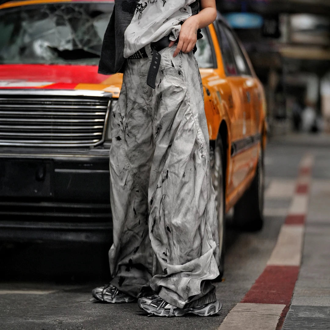 Sanhoostudio wide leg denim pants featuring distressed wash, embroidered detailing, and scythe-cut silhouette. Designed for bold streetwear styling with comfort, durability, and everyday versatility.