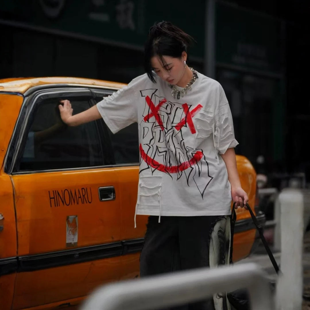 Sanhoostudio short sleeve T-shirt featuring graffiti print, tie dye finish, and patchwork design with an oversized fit silhouette. Designed for bold streetwear styling with breathable comfort, soft fabric feel, and versatile everyday wear for summer outfits.