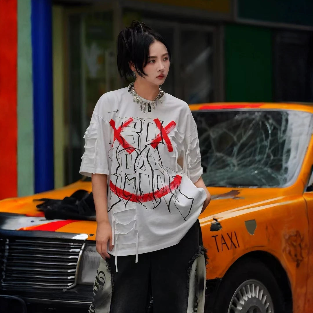 Sanhoostudio short sleeve T-shirt featuring graffiti print, tie dye finish, and patchwork design with an oversized fit silhouette. Designed for bold streetwear styling with breathable comfort, soft fabric feel, and versatile everyday wear for summer outfits.