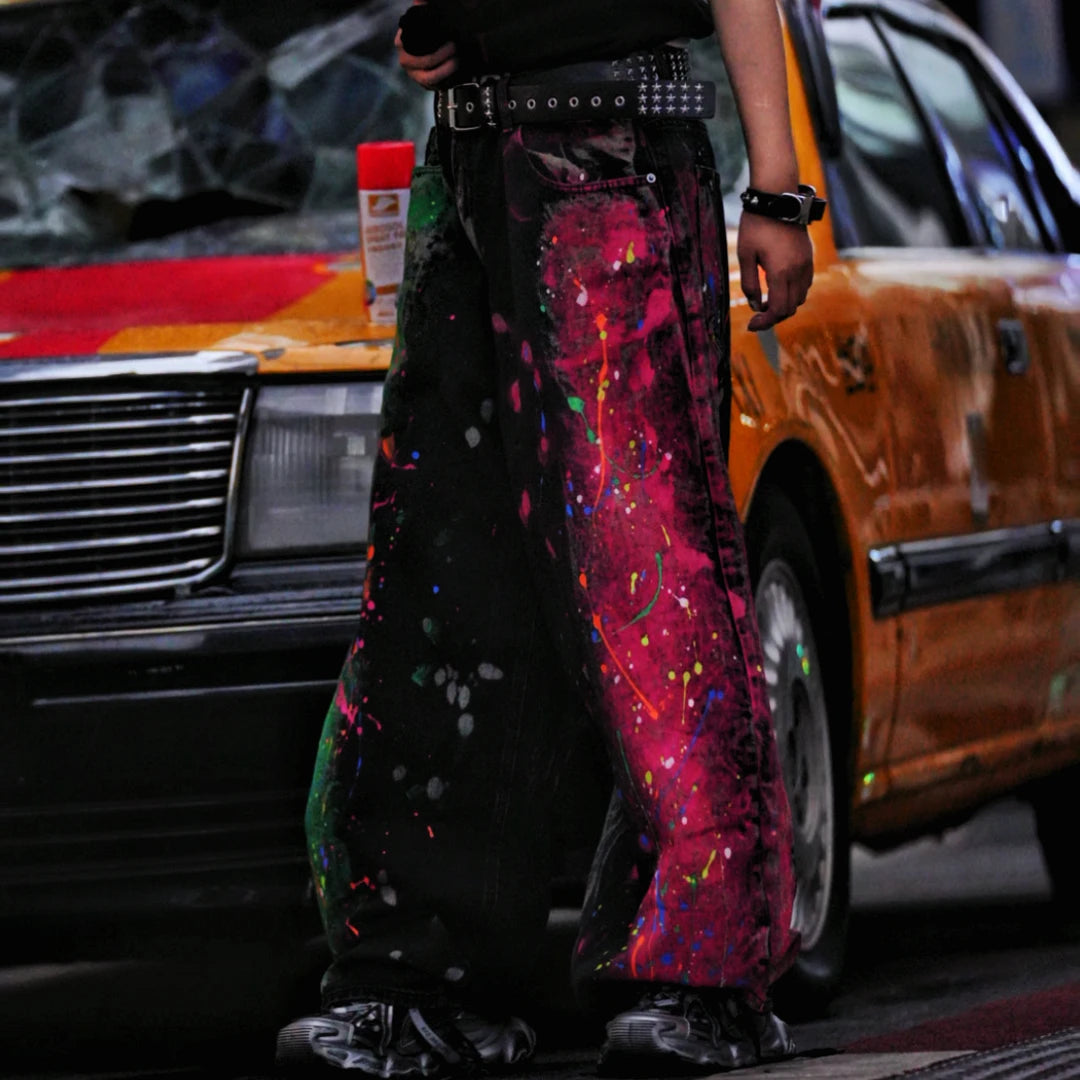 Sanhoostudio denim pants featuring graffiti artwork, patchwork construction, and distressed wash finish. Designed with a wide leg silhouette for bold streetwear styling with durability and comfort.
