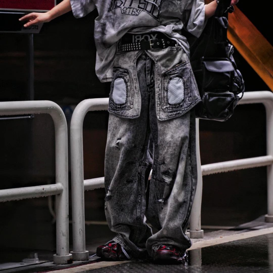 Sanhoostudio denim pants featuring layered patchwork construction, distressed wash finish, and detachable styling elements. Designed for bold streetwear outfits with relaxed comfort and unique visual structure.