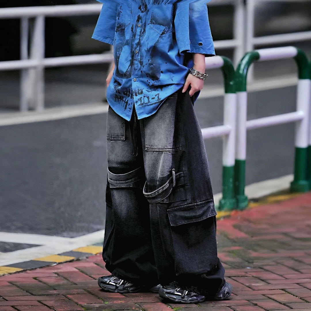 Sanhoostudio denim pants featuring colorblock patchwork construction, cargo-inspired details, distressed wash finish, and a wide leg scythe-cut silhouette. Designed for bold streetwear styling with comfort and versatility.
