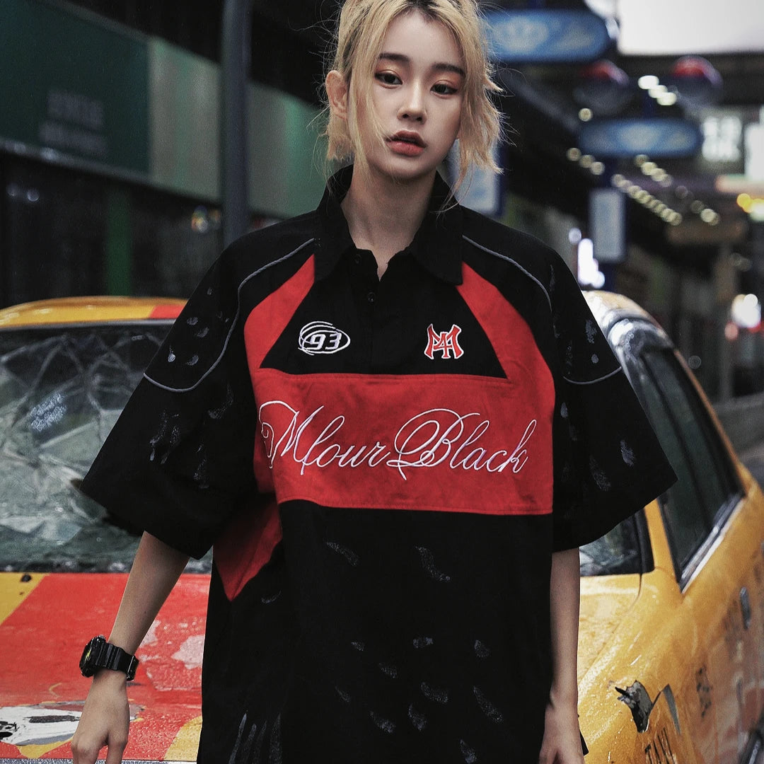 Sanhoostudio polo shirt featuring colorblock stripe detailing, letter-inspired accents, and a relaxed oversized fit. Designed for versatile summer outfits that blend casual comfort with modern streetwear aesthetics.