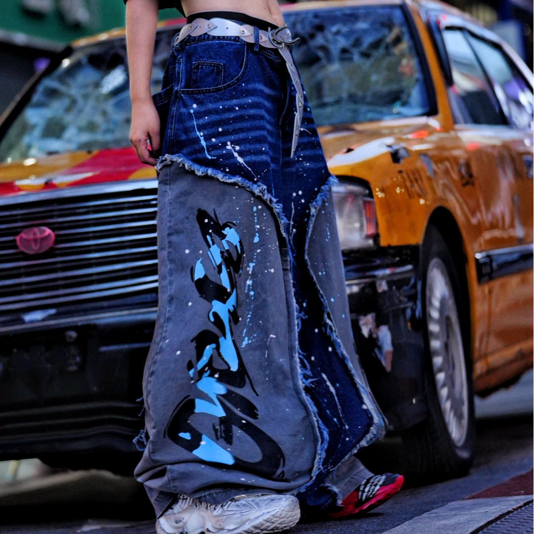 Sanhoostudio denim pants featuring distressed wash treatment, patchwork detailing, and a wide leg scythe-cut silhouette. Designed for contemporary streetwear styling with comfort and standout structure.