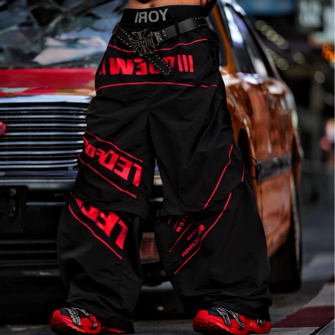 Sanhoostudio track pants featuring detachable design details, racing-inspired panel construction, and lightweight quick-dry fabric. Built for active streetwear styling with comfort, flexibility, and everyday versatility.