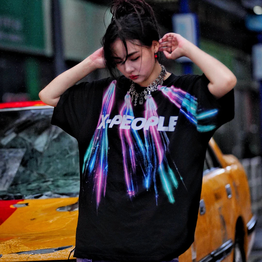 Sanhoostudio short sleeve T-shirt featuring colorful spray-print artwork, breathable fabric construction, and an oversized silhouette. Designed for summer streetwear styling with lightweight comfort and bold graphic appeal.