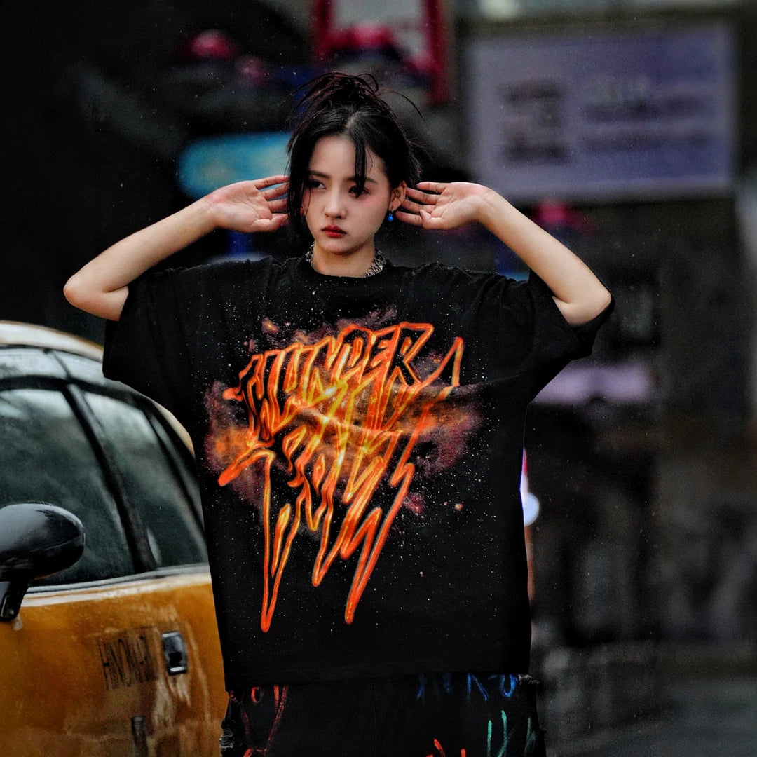 Sanhoostudio short sleeve T-shirt featuring gold-inspired spray-print graphics, breathable fabric construction, and a relaxed oversized fit. Built for standout summer streetwear outfits with comfort and unique visual expression.