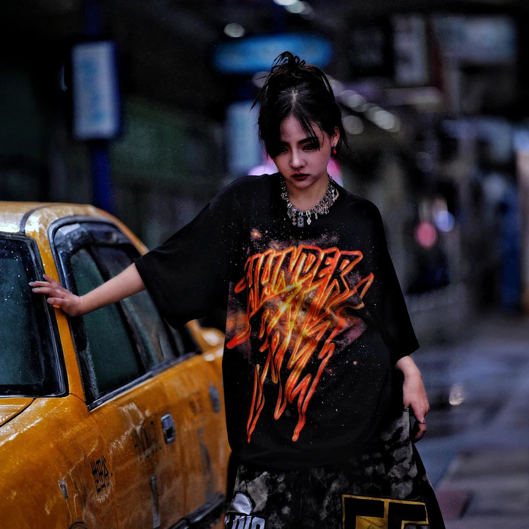 Sanhoostudio short sleeve T-shirt featuring gold-inspired spray-print graphics, breathable fabric construction, and a relaxed oversized fit. Built for standout summer streetwear outfits with comfort and unique visual expression.