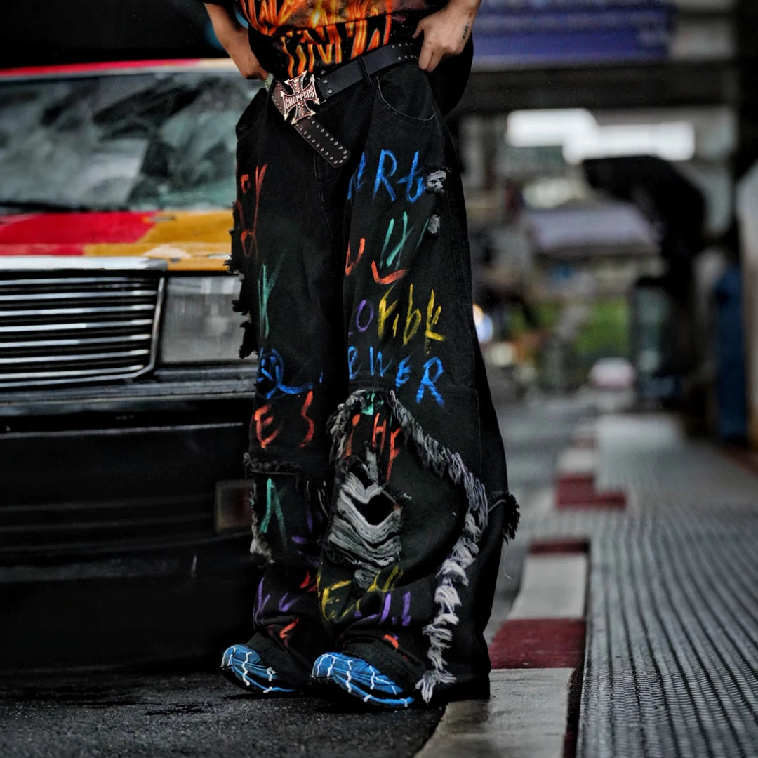 Sanhoostudio convertible denim pants featuring detachable long-to-short functionality, distressed wash treatment, and a wide leg scythe-cut silhouette. Designed for versatile streetwear styling with comfort and standout visual appeal.