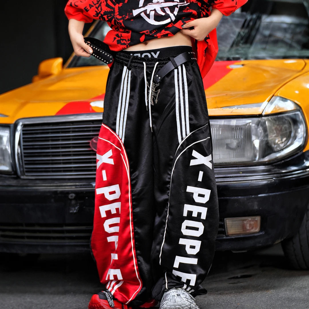Sanhoostudio wide leg pants featuring lightweight glossy fabric construction and a scythe-cut silhouette with a relaxed fit. Designed for breathable summer styling with comfort, movement, and contemporary streetwear appeal.