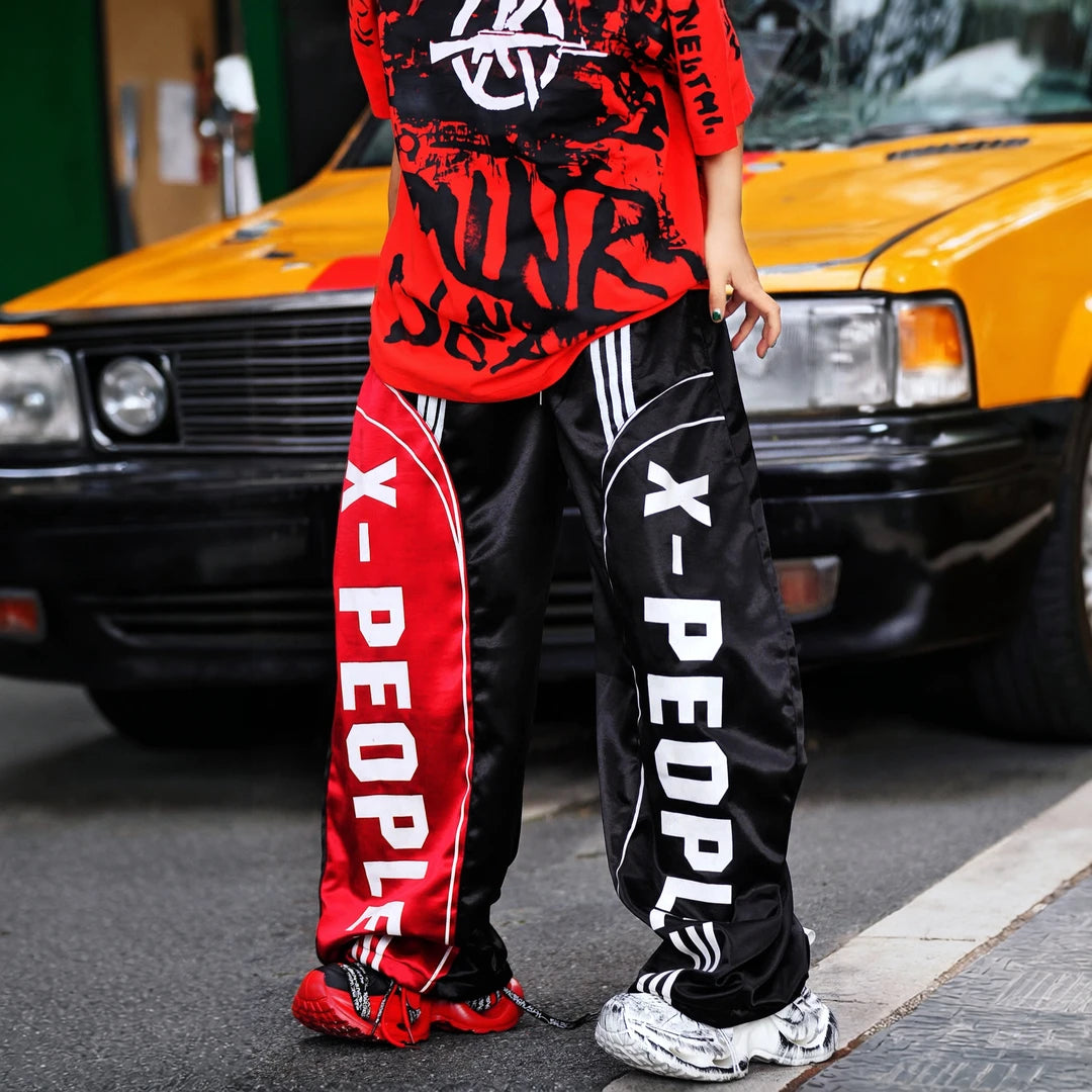 Sanhoostudio wide leg pants featuring lightweight glossy fabric construction and a scythe-cut silhouette with a relaxed fit. Designed for breathable summer styling with comfort, movement, and contemporary streetwear appeal.
