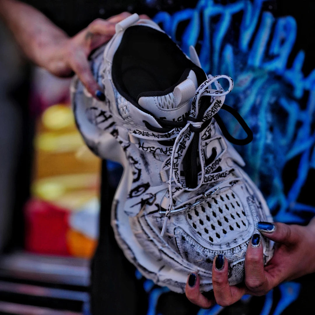 Sanhoostudio dad sneakers featuring grey and white graffiti-inspired detailing, cushioned sole construction, and a modern streetwear silhouette. Designed for everyday comfort, versatile styling, and standout urban fashion appeal with all-day wearability.