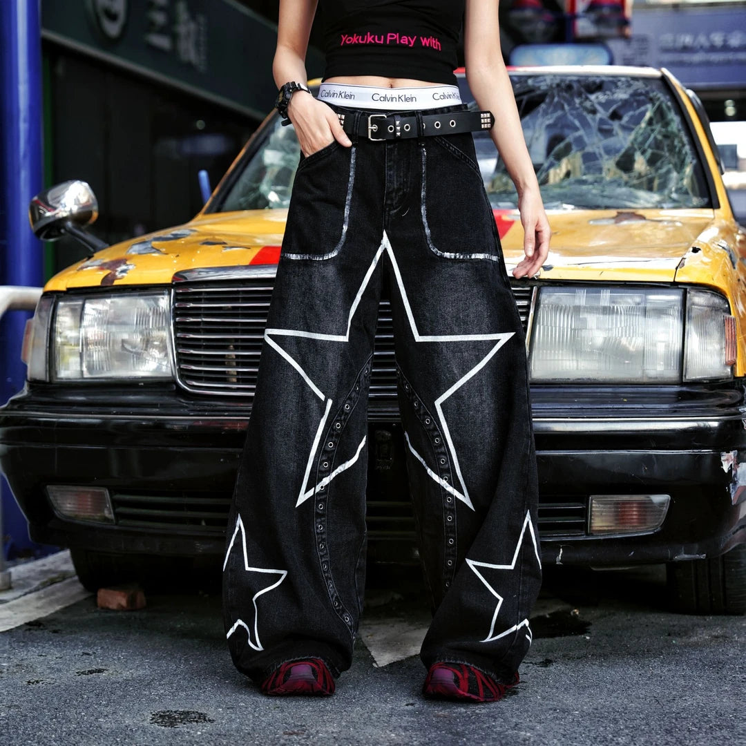 Sanhoostudio denim pants featuring star graffiti artwork, deconstructed styling details, and a wide leg scythe-cut silhouette. Built for standout streetwear outfits with relaxed comfort and premium visual appeal.