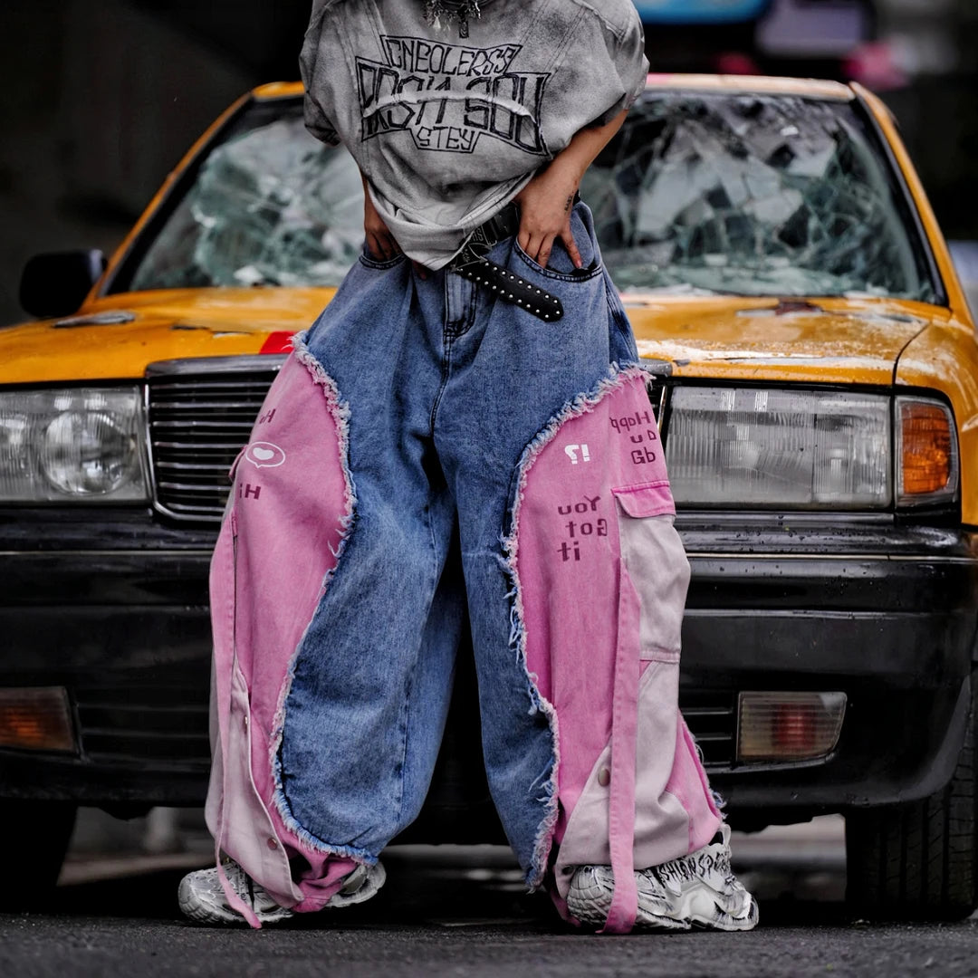 Sanhoostudio denim pants featuring distressed wash treatment, patchwork detailing, and a wide leg scythe-cut silhouette. Designed for modern streetwear styling with relaxed comfort and standout visual character for everyday wear.