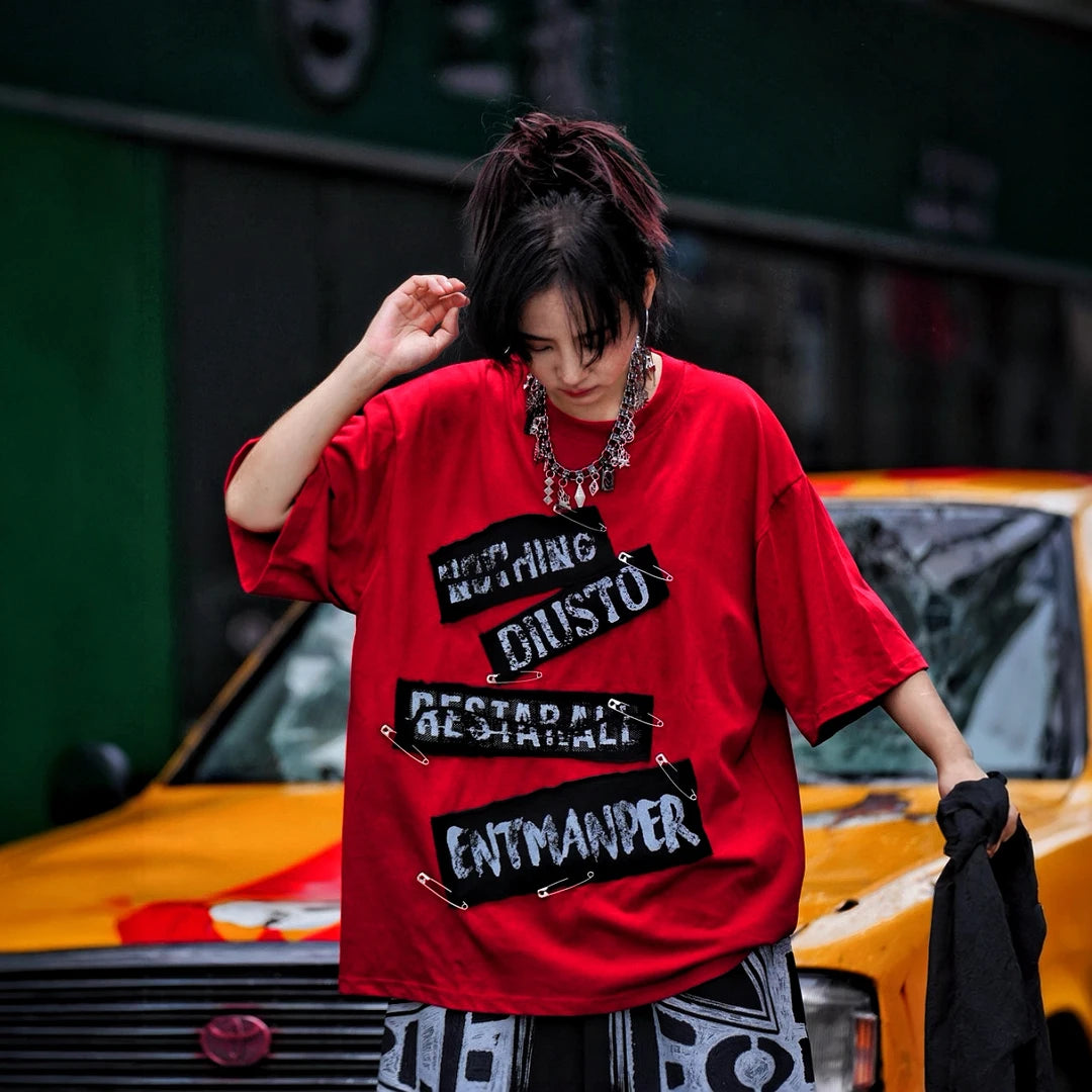 Sanhoostudio short sleeve T-shirt featuring red graphic artwork and breathable lightweight construction with an oversized fit. Designed for summer streetwear styling with standout visual impact and comfortable daily wear.