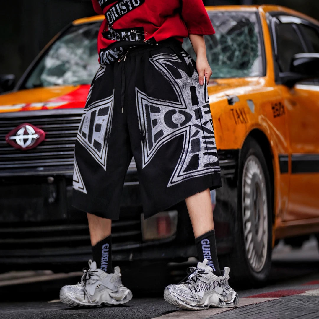 Sanhoostudio shorts featuring distressed wash treatment, graffiti detailing, and cross-inspired design elements with a relaxed fit. Built for summer streetwear outfits with breathable comfort and versatile styling appeal.