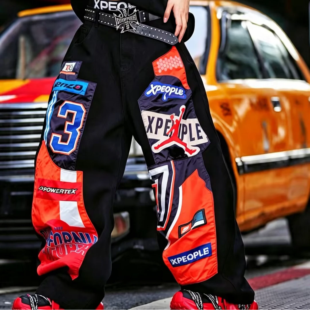 Sanhoostudio denim pants featuring patchwork applique detailing, distressed washed finish, and a wide leg scythe-cut silhouette. Designed for contemporary streetwear styling with relaxed comfort, durable construction, and standout everyday versatility.
