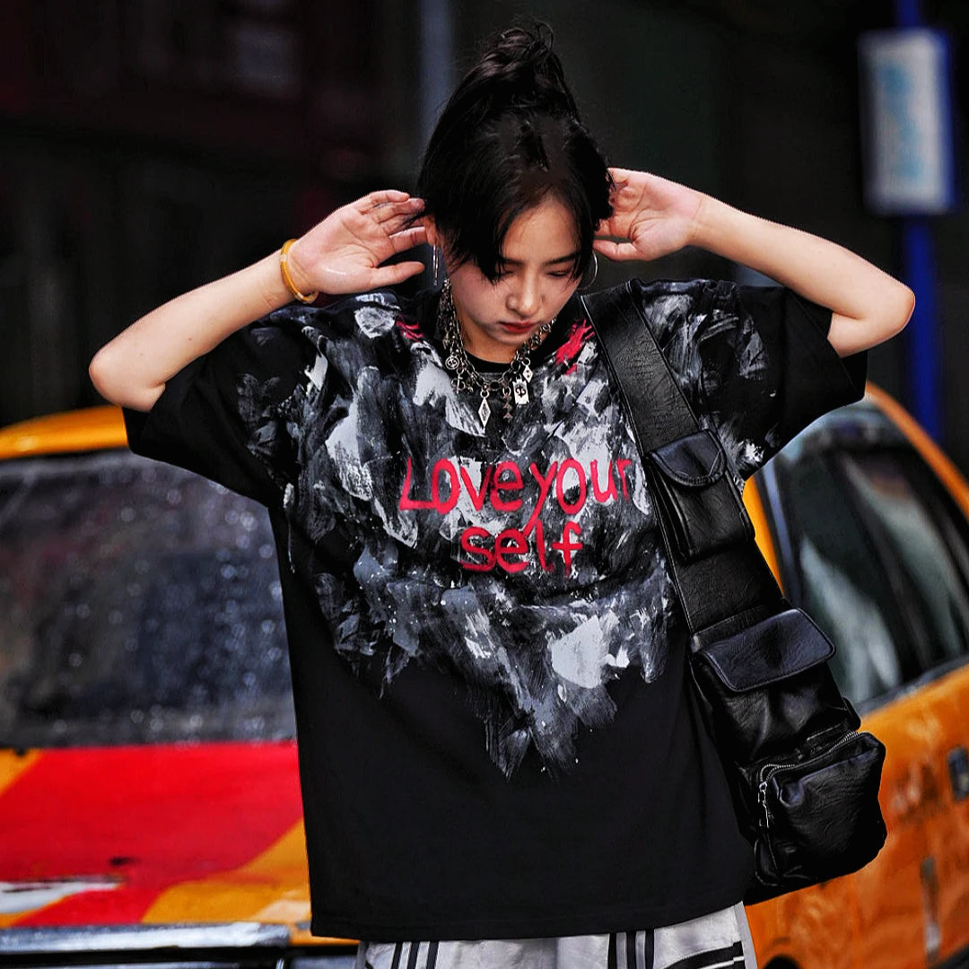 Sanhoostudio short sleeve T-shirt featuring abstract spray-print artwork, breathable fabric construction, and a relaxed oversized fit. Designed for modern streetwear styling with lightweight comfort, bold graphic appeal, and versatile summer wear.