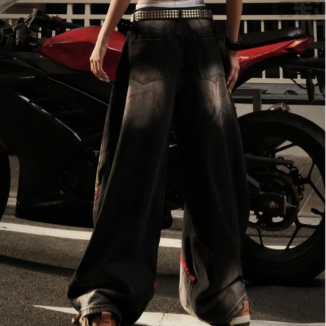 Sanhoostudio denim pants featuring frayed patchwork detailing, distressed wash treatment, and a relaxed scythe-cut silhouette. Designed for modern streetwear styling with a loose straight-leg fit, vintage character, and versatile everyday appeal.