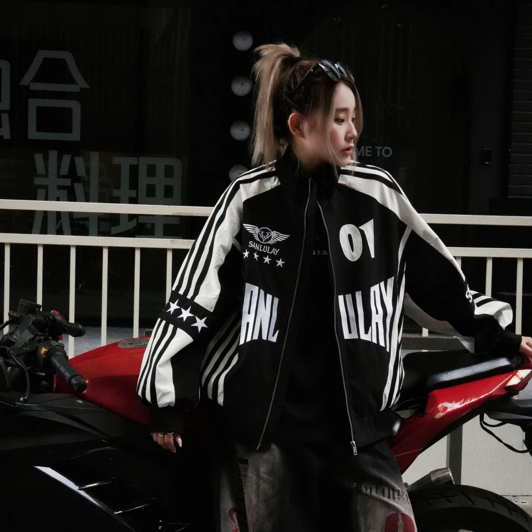 Sanhoostudio varsity jacket featuring red and black colorblock construction, number applique embroidery, striped detailing, and a relaxed oversized fit. Inspired by vintage racing and varsity aesthetics for bold fall streetwear styling and comfortable everyday wear.
