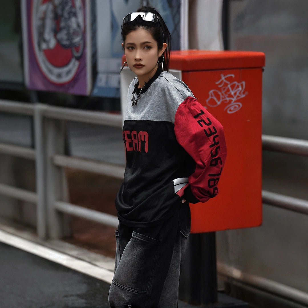 Sanhoostudio T-shirt featuring red, black, and grey colorblock patchwork with number and letter graphic prints. Designed with a relaxed streetwear silhouette for bold everyday styling, comfortable wear, and a distinctive high-street aesthetic.