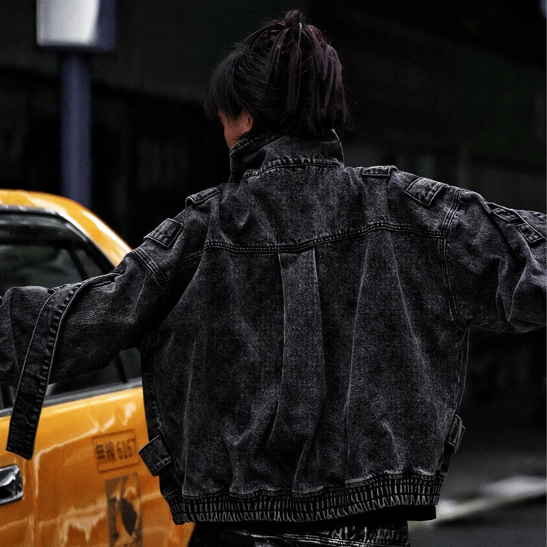 Sanhoostudio denim jacket featuring rock grey tones, hand-painted graffiti details, distressed staining, mud-dye treatment, and a relaxed oversized silhouette. Designed for statement streetwear layering with rugged visual texture, vintage-inspired character, and bold everyday urban styling.