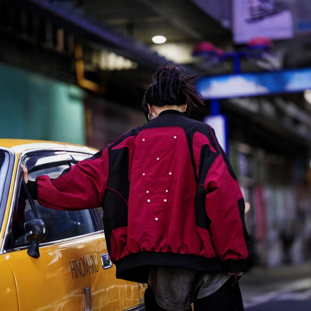 Sanhoostudio racing jacket featuring contrast patchwork construction, embroidered detailing, padded insulation, and a relaxed oversized silhouette. Designed for colder-season streetwear styling with vintage motorsport influence, comfortable warmth, bold visual structure, and versatile everyday layering.