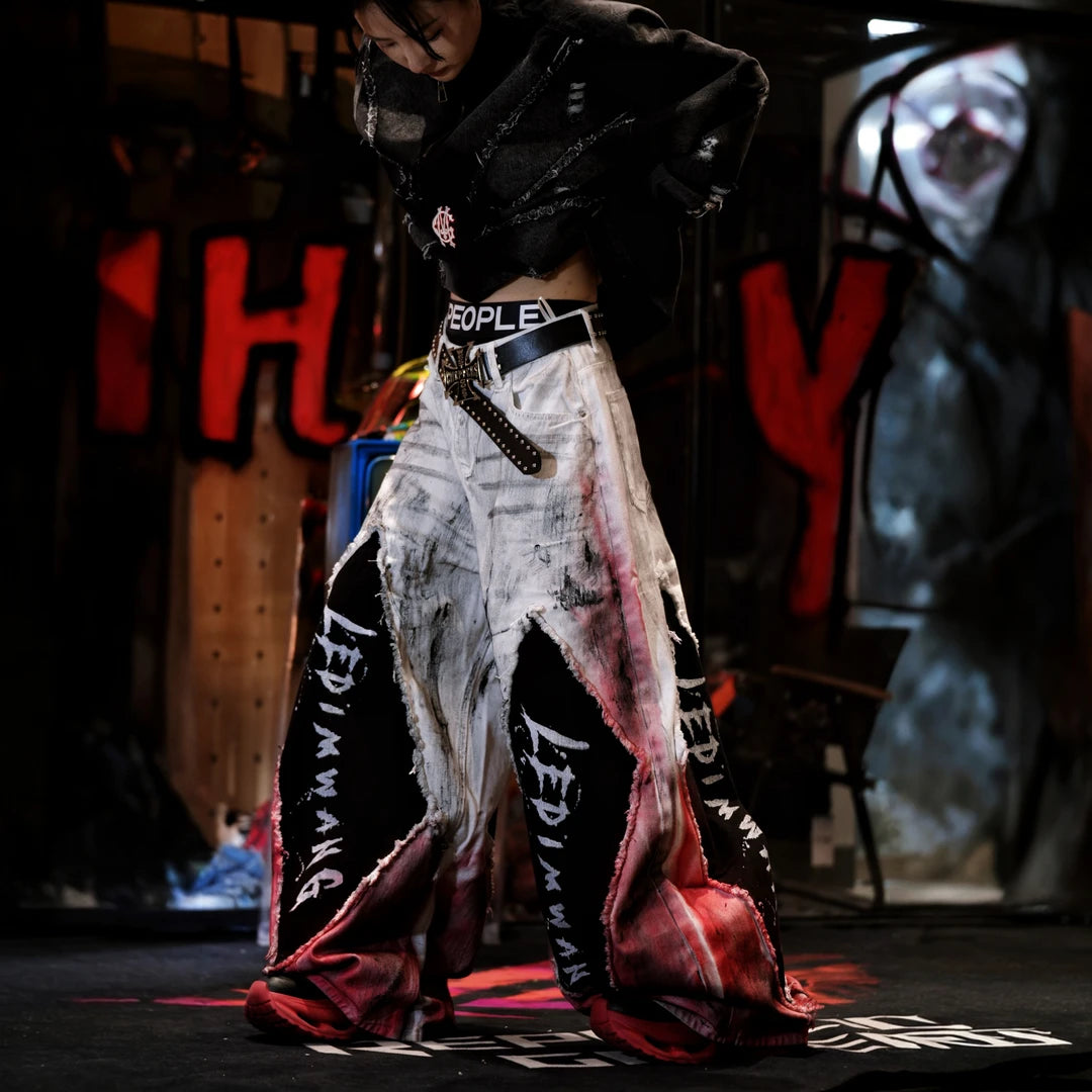 Sanhoostudio denim pants featuring a layered design, vintage washed treatment, distressed detailing, and asymmetric patchwork construction. Designed for statement streetwear styling with rugged denim texture, unconventional panel structure, relaxed proportions, and distinctive everyday urban appeal.