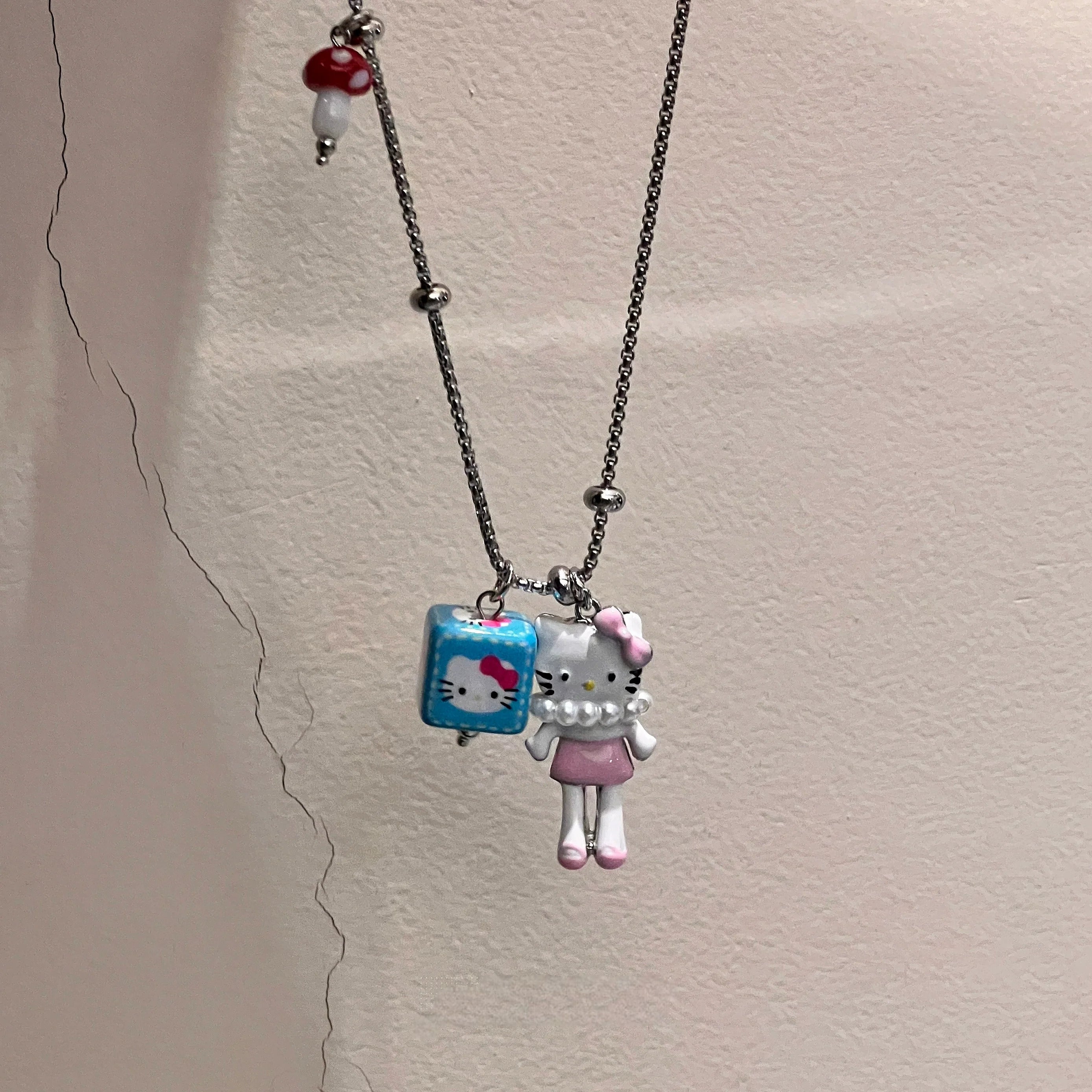 Sanhoostudio’s cute KT cat cartoon necklace adds a fun, youthful touch to any outfit. Designed for playful streetwear and kawaii-inspired fashion, it’s perfect for bold and quirky style statements.