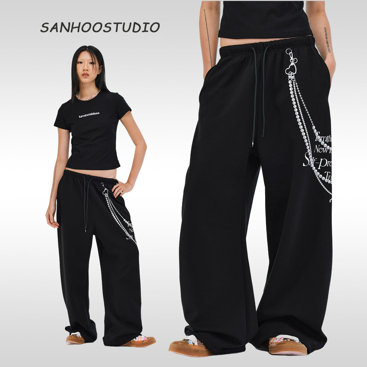 These Sanhoostudio pants stand out with pearl chain embellishments and bold slogan prints, merging casual comfort with high street individuality. Designed with a relaxed fit, they highlight a balance of playful accessories and edgy fashion vibes.