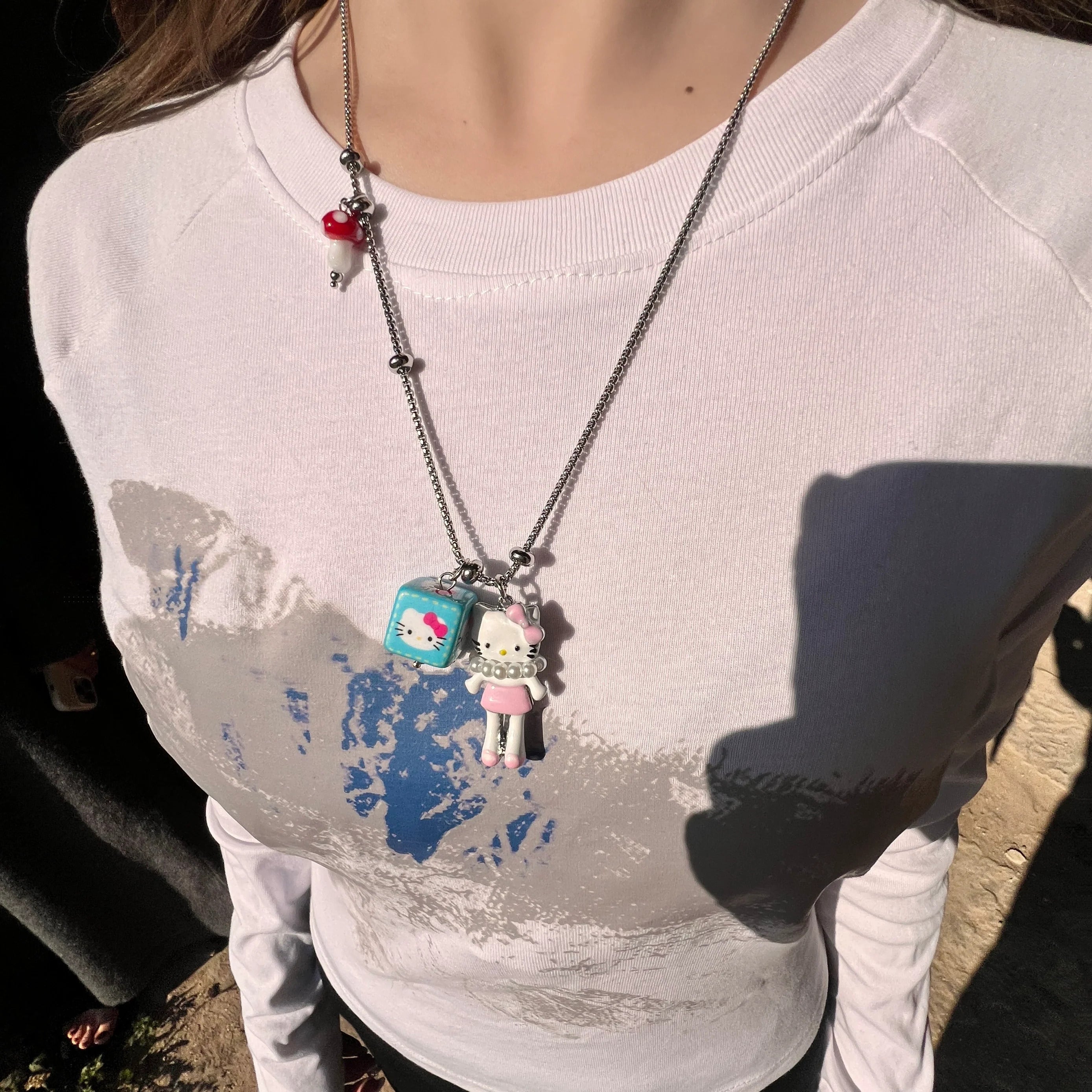 Sanhoostudio’s cute KT cat cartoon necklace adds a fun, youthful touch to any outfit. Designed for playful streetwear and kawaii-inspired fashion, it’s perfect for bold and quirky style statements.