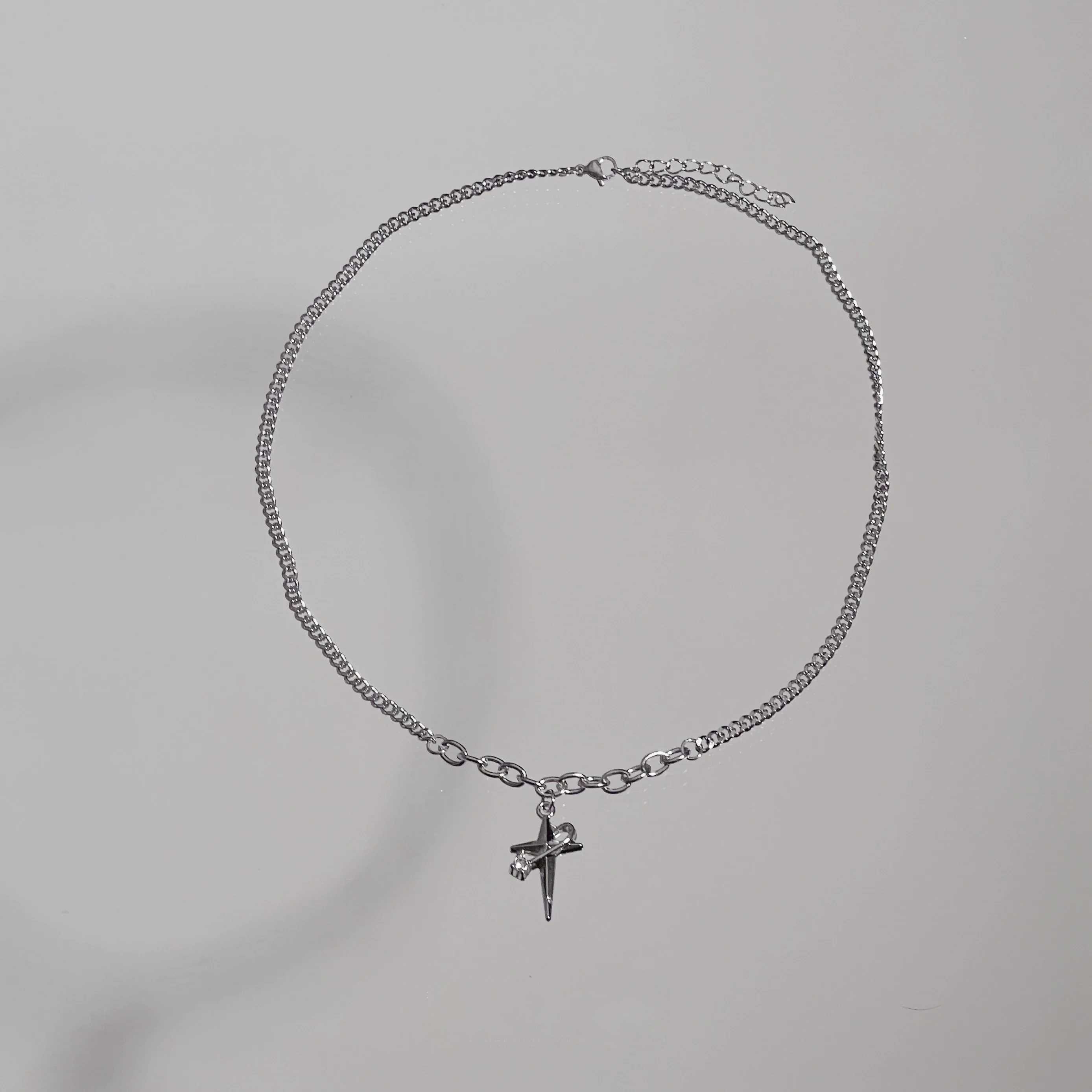 Sanhoostudio’s star cross wrap titanium necklace wraps gothic motifs into layered titanium design—sturdy, stylish, and ideal for dark-luxe streetwear and layered accessorizing.