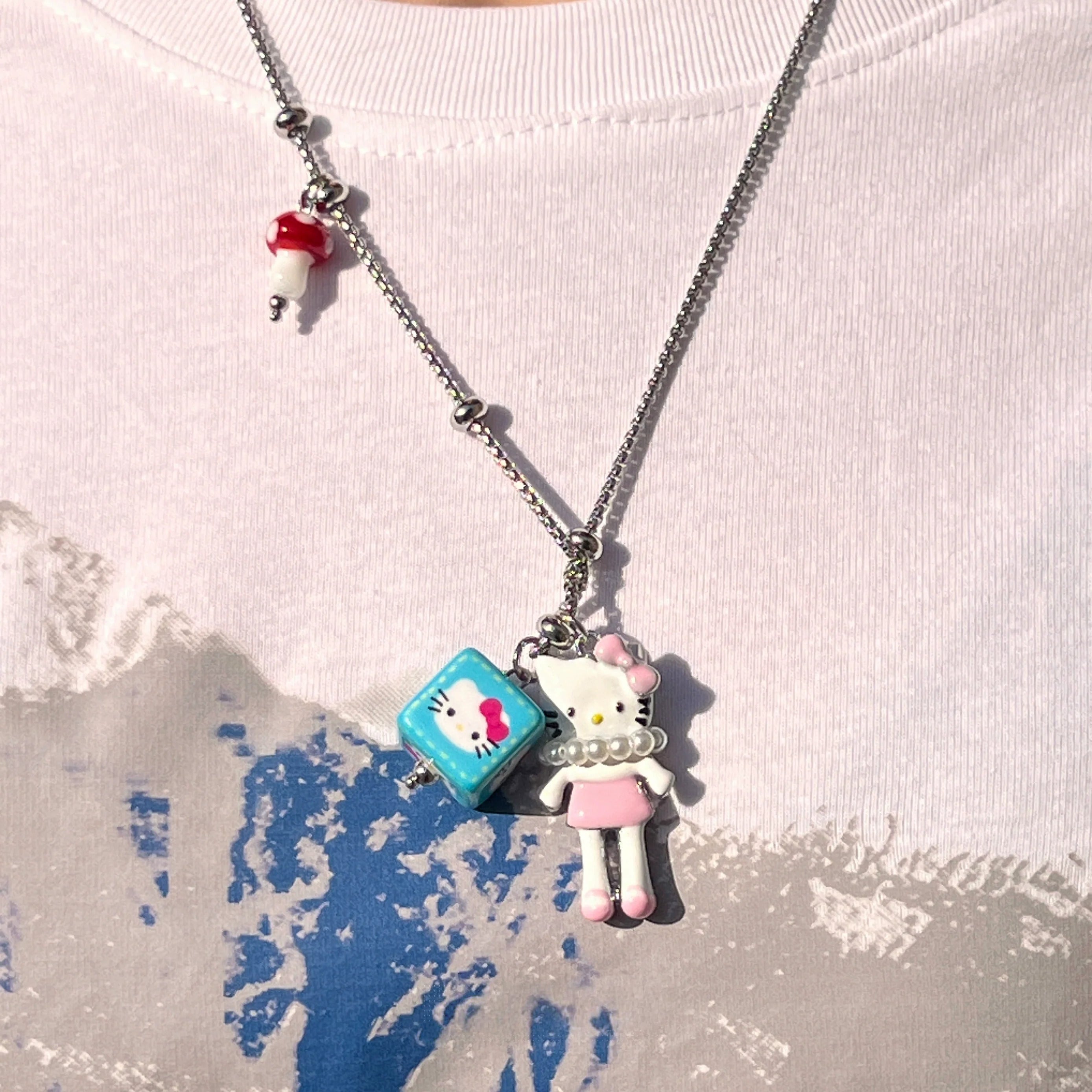 Sanhoostudio’s cute KT cat cartoon necklace adds a fun, youthful touch to any outfit. Designed for playful streetwear and kawaii-inspired fashion, it’s perfect for bold and quirky style statements.