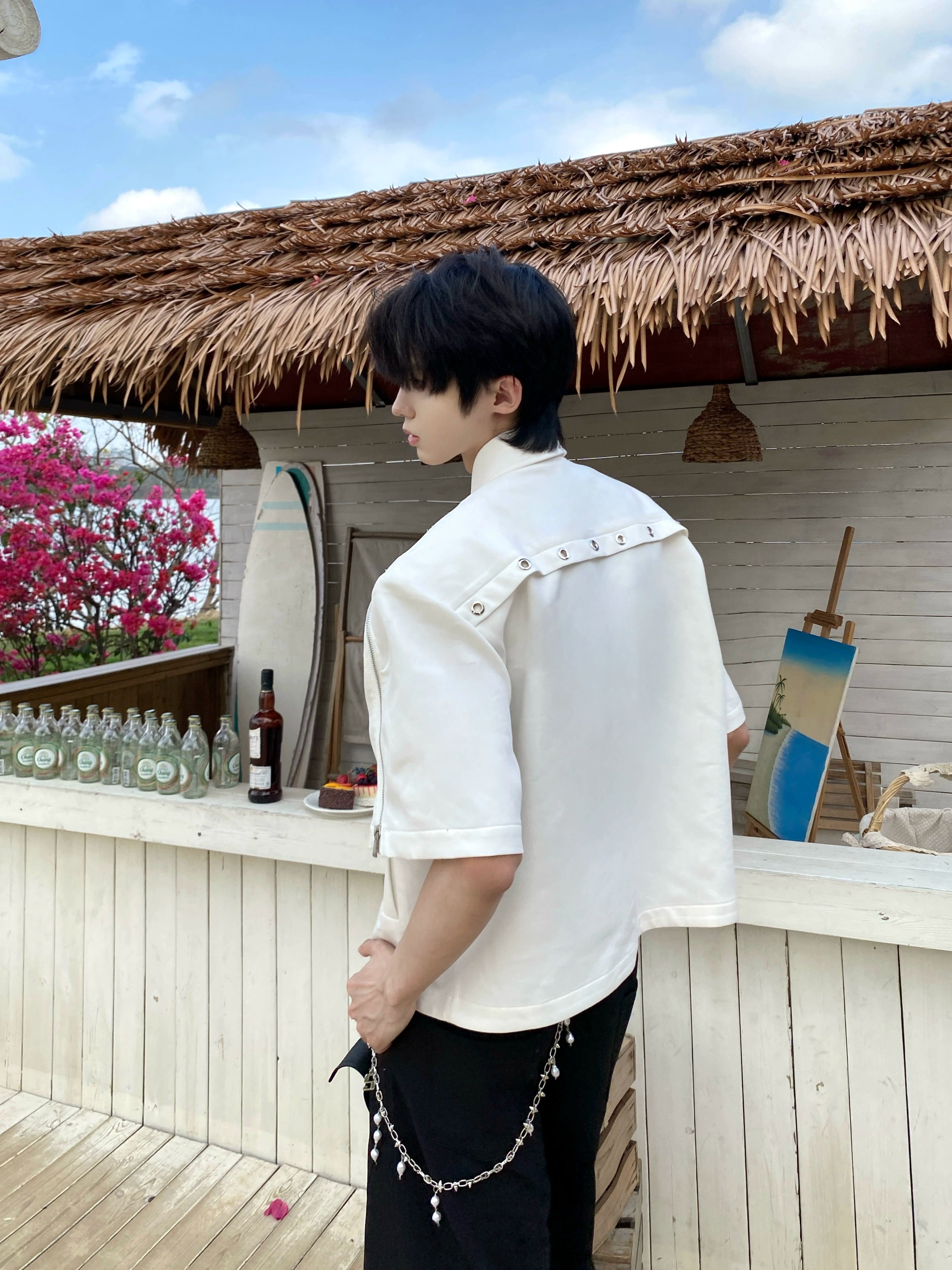 This avant-garde cropped jacket by Sanhoostudio showcases futuristic hollow-metal inspired cutouts with bold shoulder pads. Its oversized silhouette, lightweight material, and modern edge make it a standout layering piece for streetwear fans who embrace unique design and cutting-edge style.